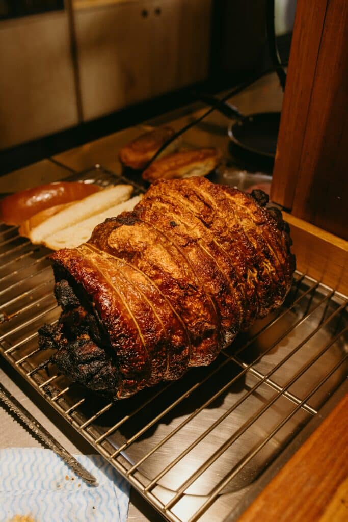 About me 1 Golden brown roasted meat resting on a wire rack, ready for slicing