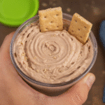 The Best And Easy Ninja Creami Protein Ice Cream 4 A rich and creamy Ninja Creami protein ice cream served in a clear glass with graham crackers on top